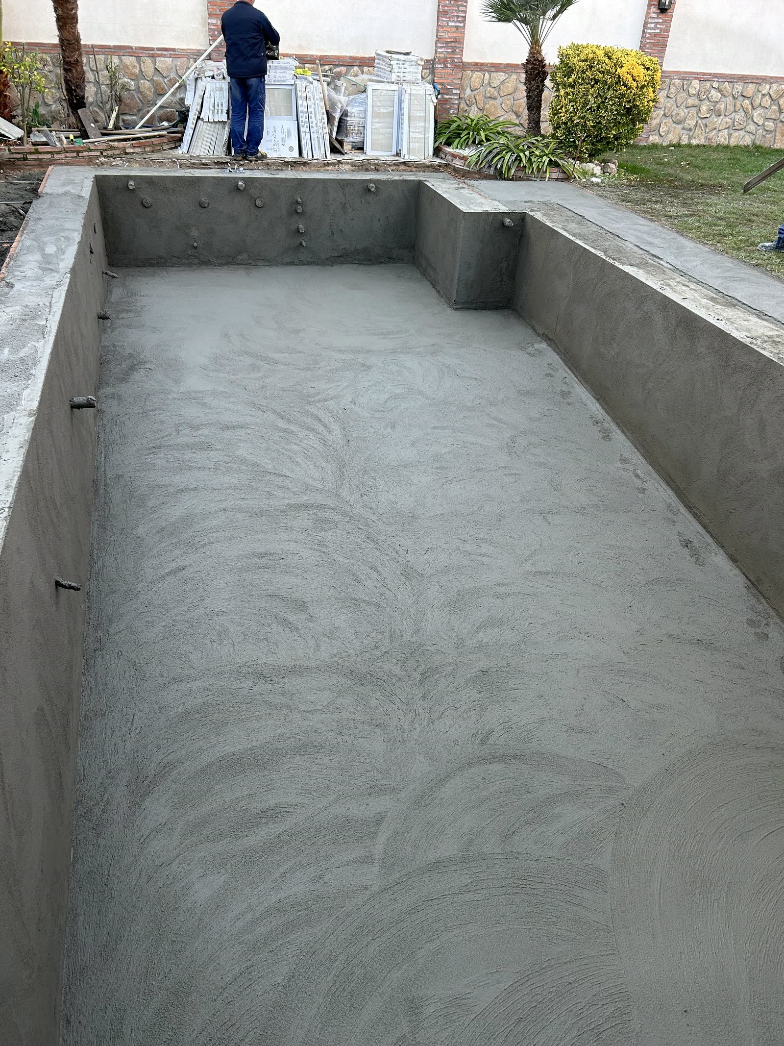 Vaso recién proyectado, con las boquillas de impulsión asomando del hormigón y la superficie todavía marcada por el fratás.